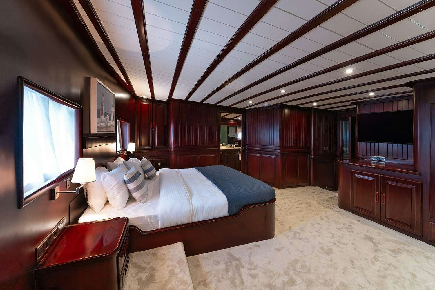 a bedroom with a large screen aboard ALWAYS SMILE Yacht for Charter