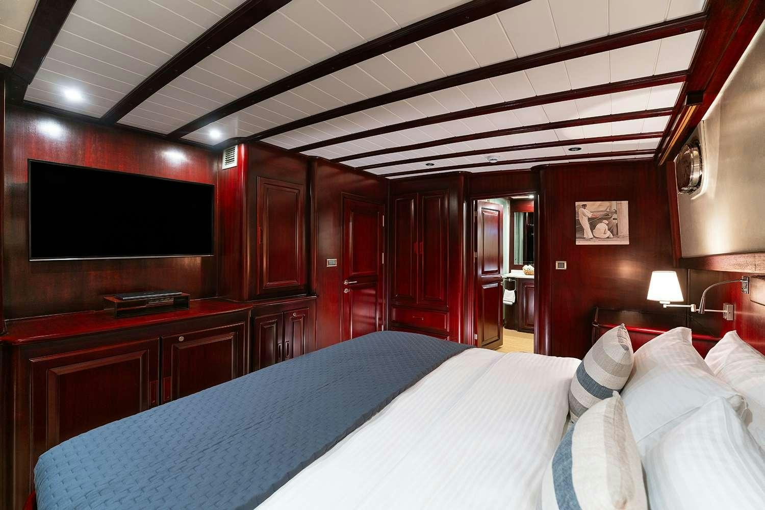 a bedroom with a bed and a television aboard ALWAYS SMILE Yacht for Charter