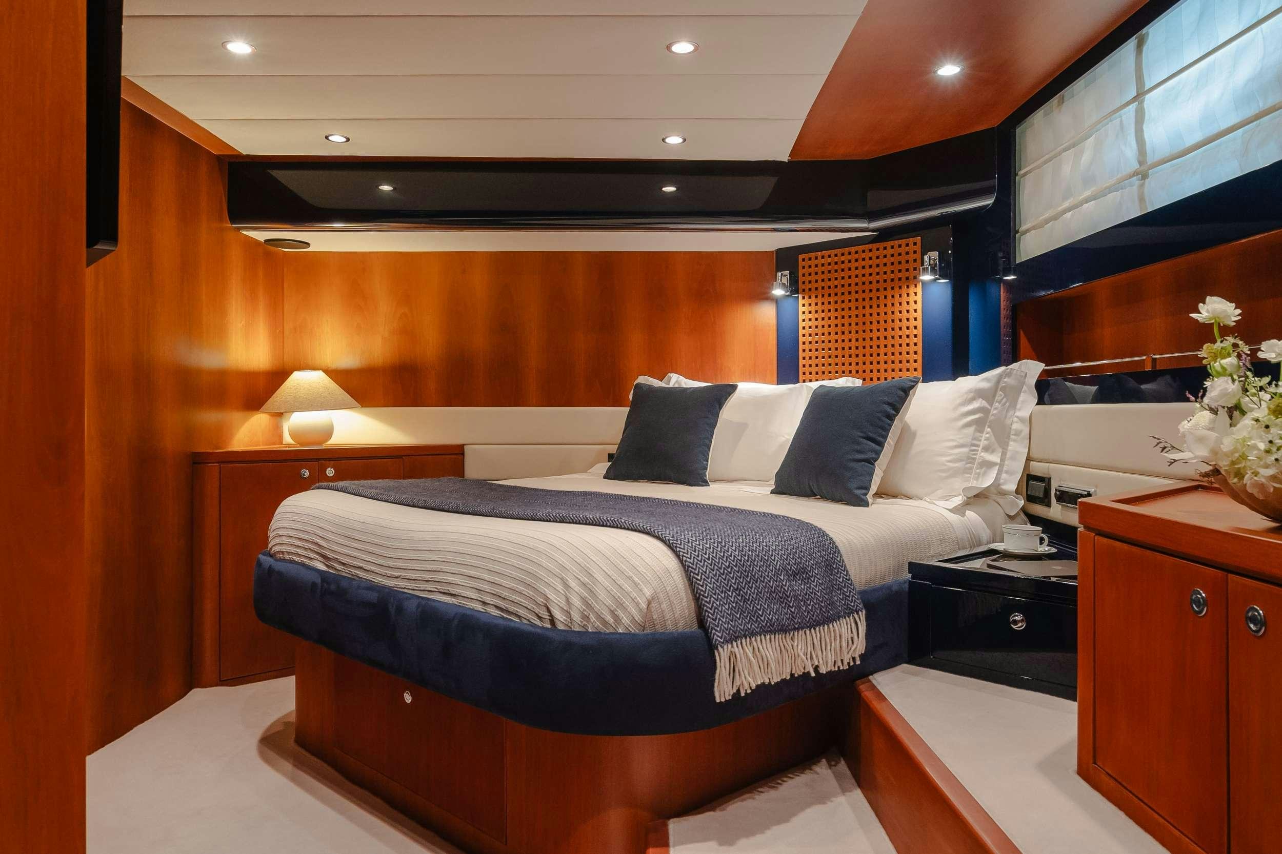 a bed with a blue comforter aboard ETERNO Yacht for Charter