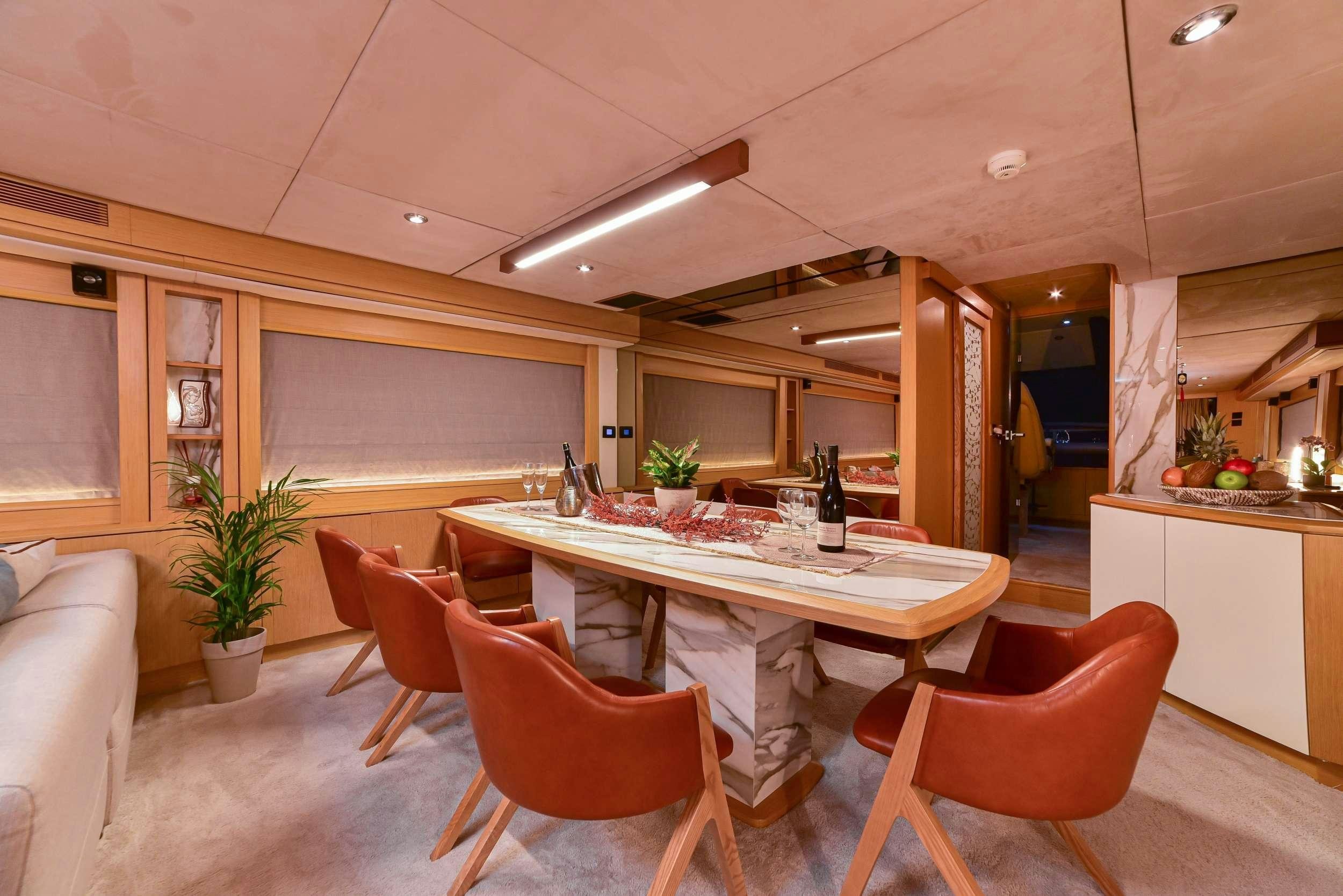 a kitchen with a table and chairs aboard STELA 117 Yacht for Charter