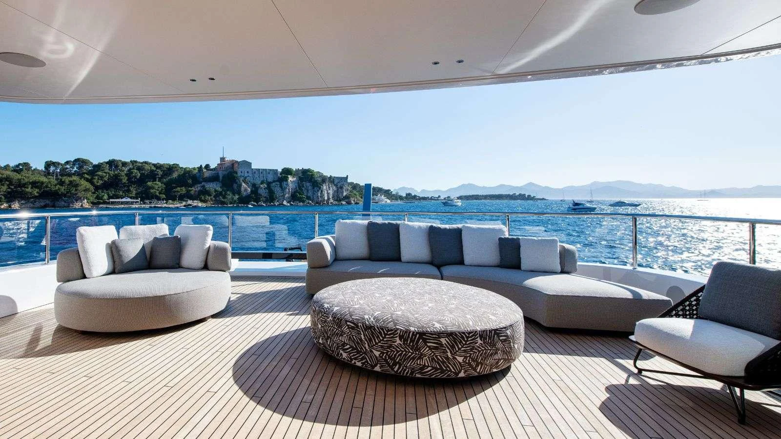 a large living room with a large balcony overlooking a body of water aboard NORTHERN ESCAPE Yacht for Charter