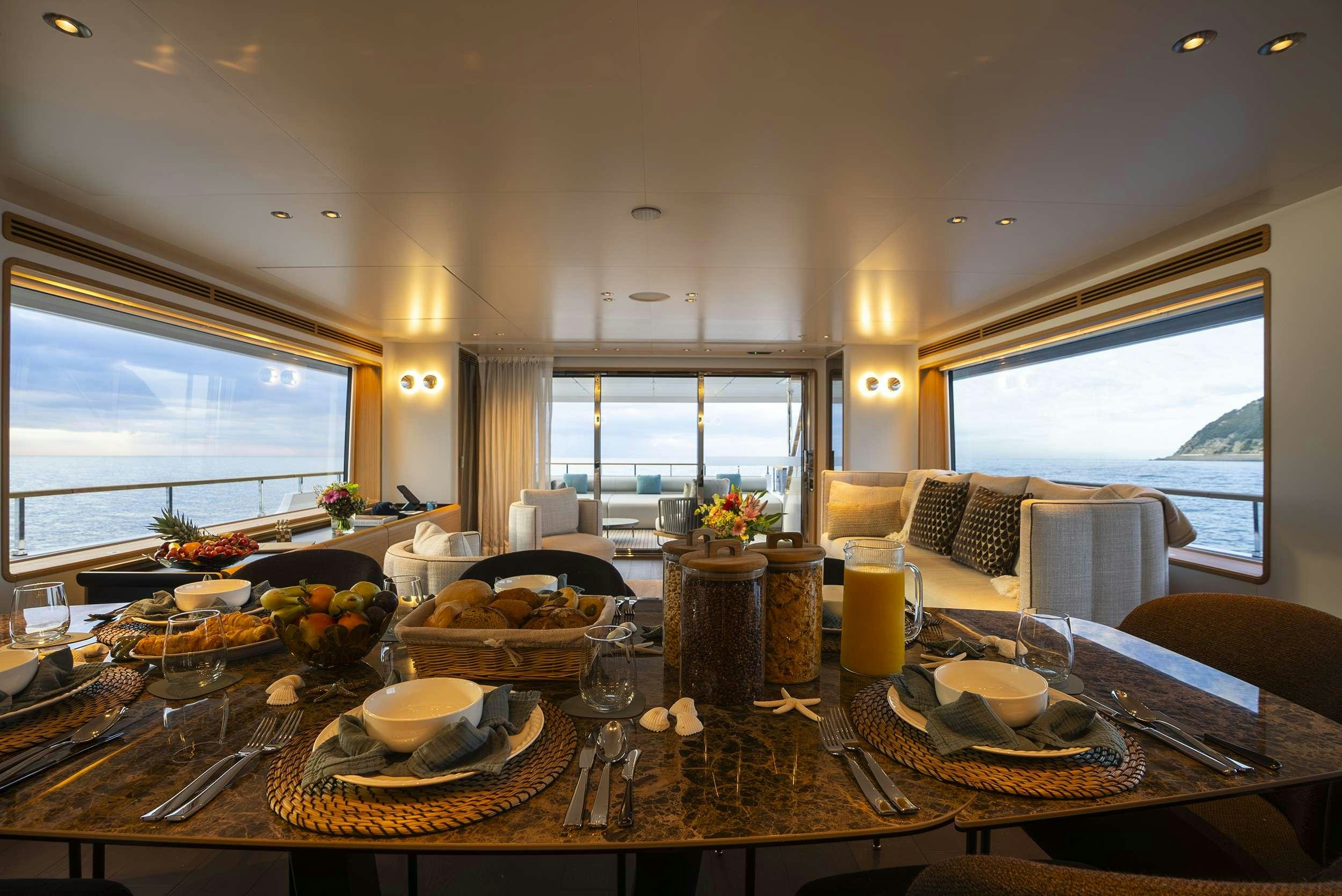 a large dining table with food and candles on it aboard RARE GEM Yacht for Charter