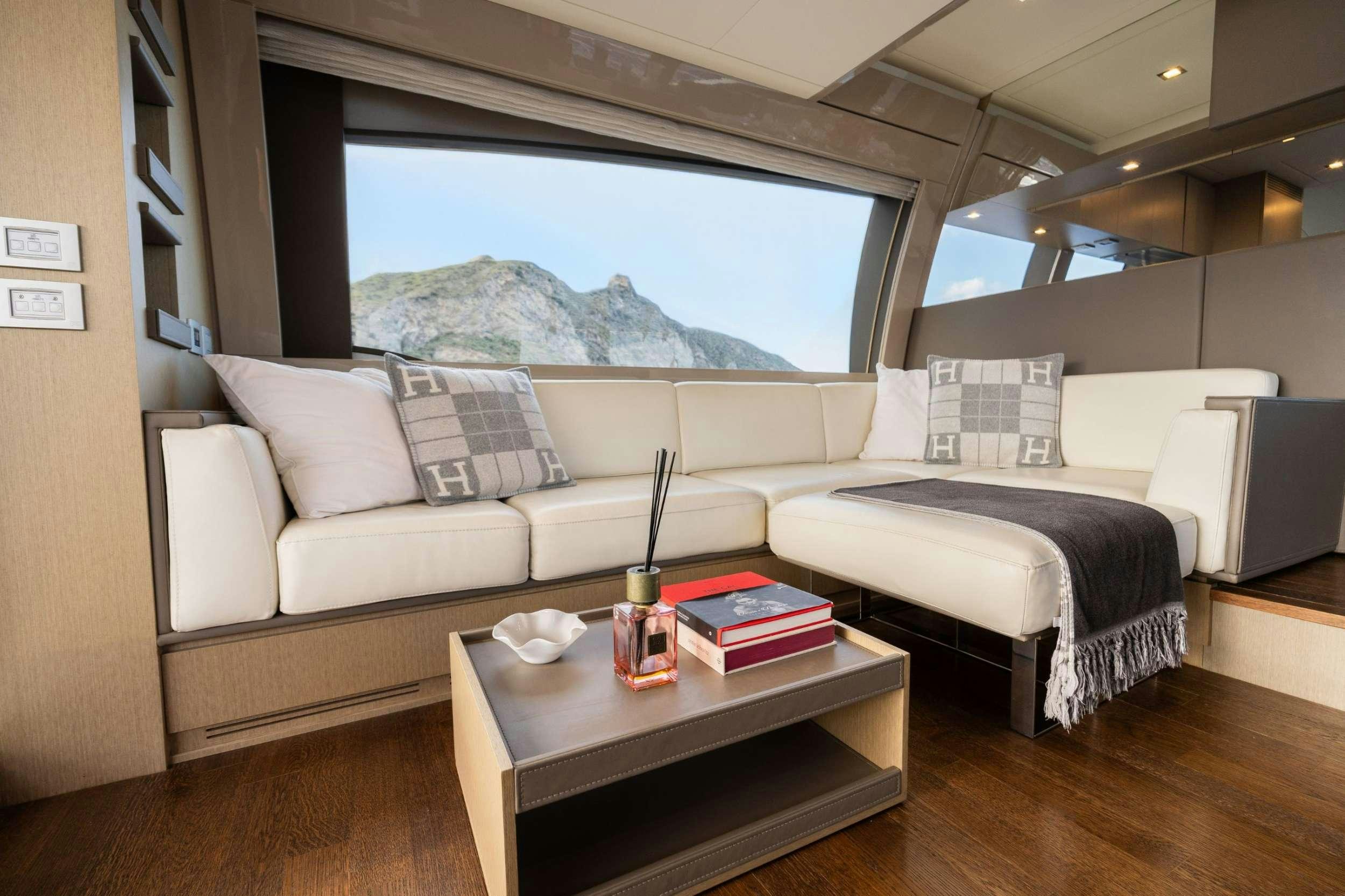 a room with a couch and a table with a glass of wine aboard SEA SONS Yacht for Charter