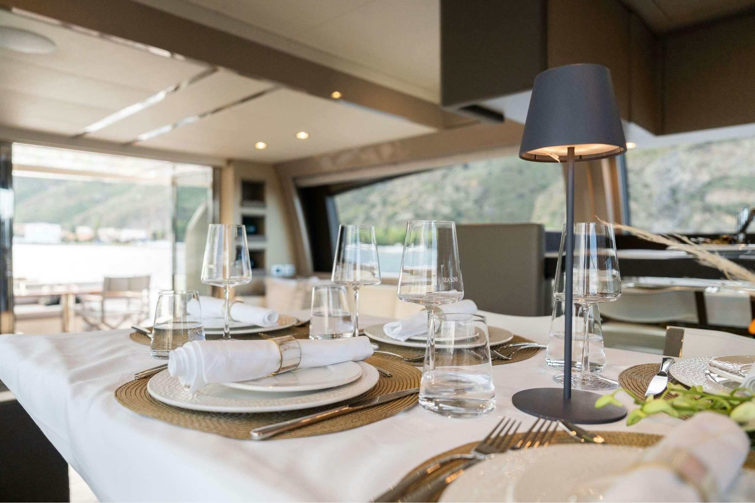 a table with plates and glasses aboard SEA SONS Yacht for Charter