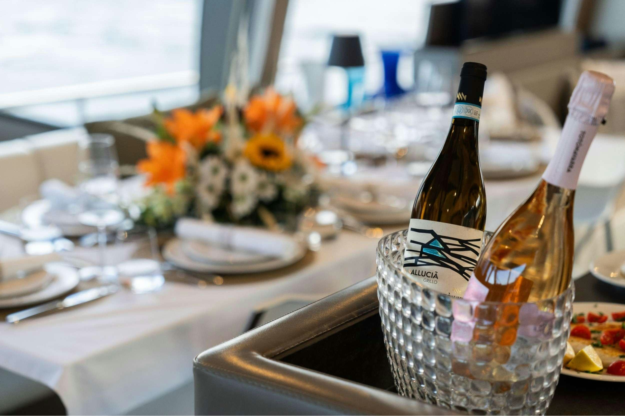 a table with a bottle and flowers aboard SEA SONS Yacht for Charter