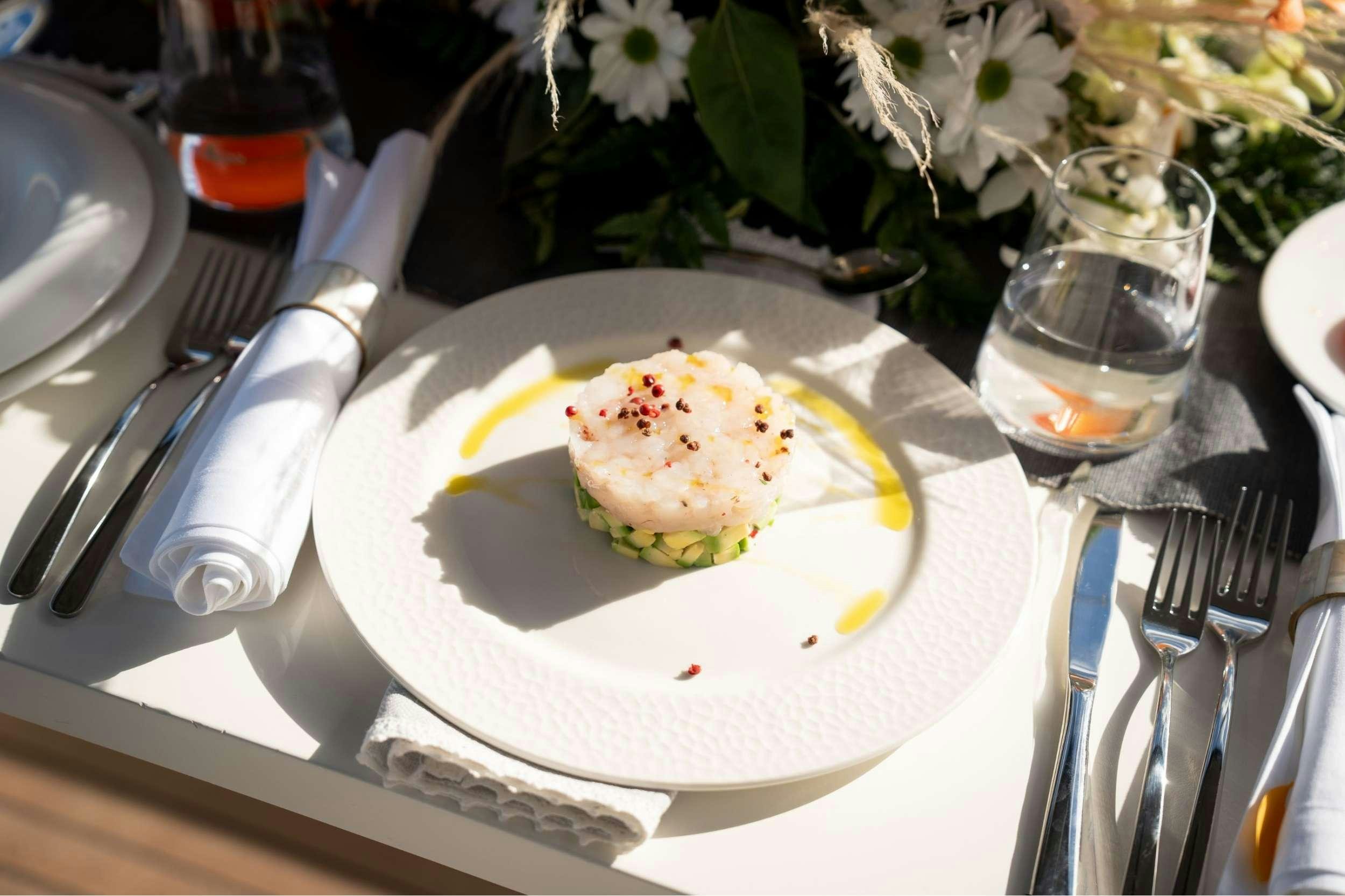 a plate of food and a glass of beer on a table aboard SEA SONS Yacht for Charter