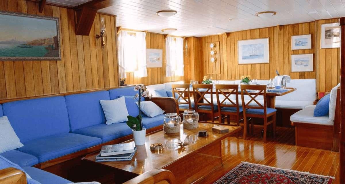 a living room with a blue couch and a table aboard SIR WINSTON CHURCHILL Yacht for Charter