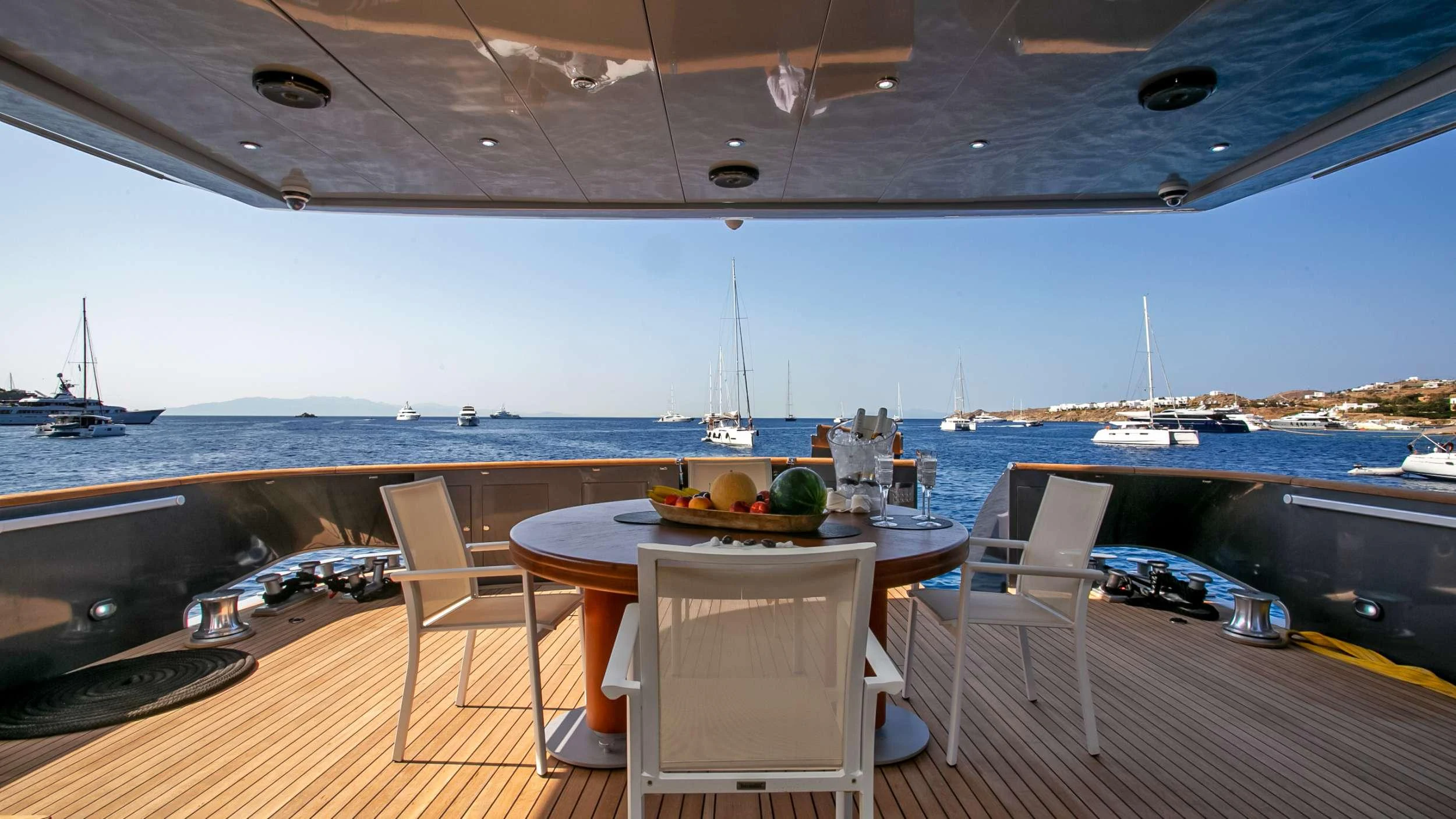 a table and chairs on a deck overlooking a body of water aboard MARAYA Yacht for Charter