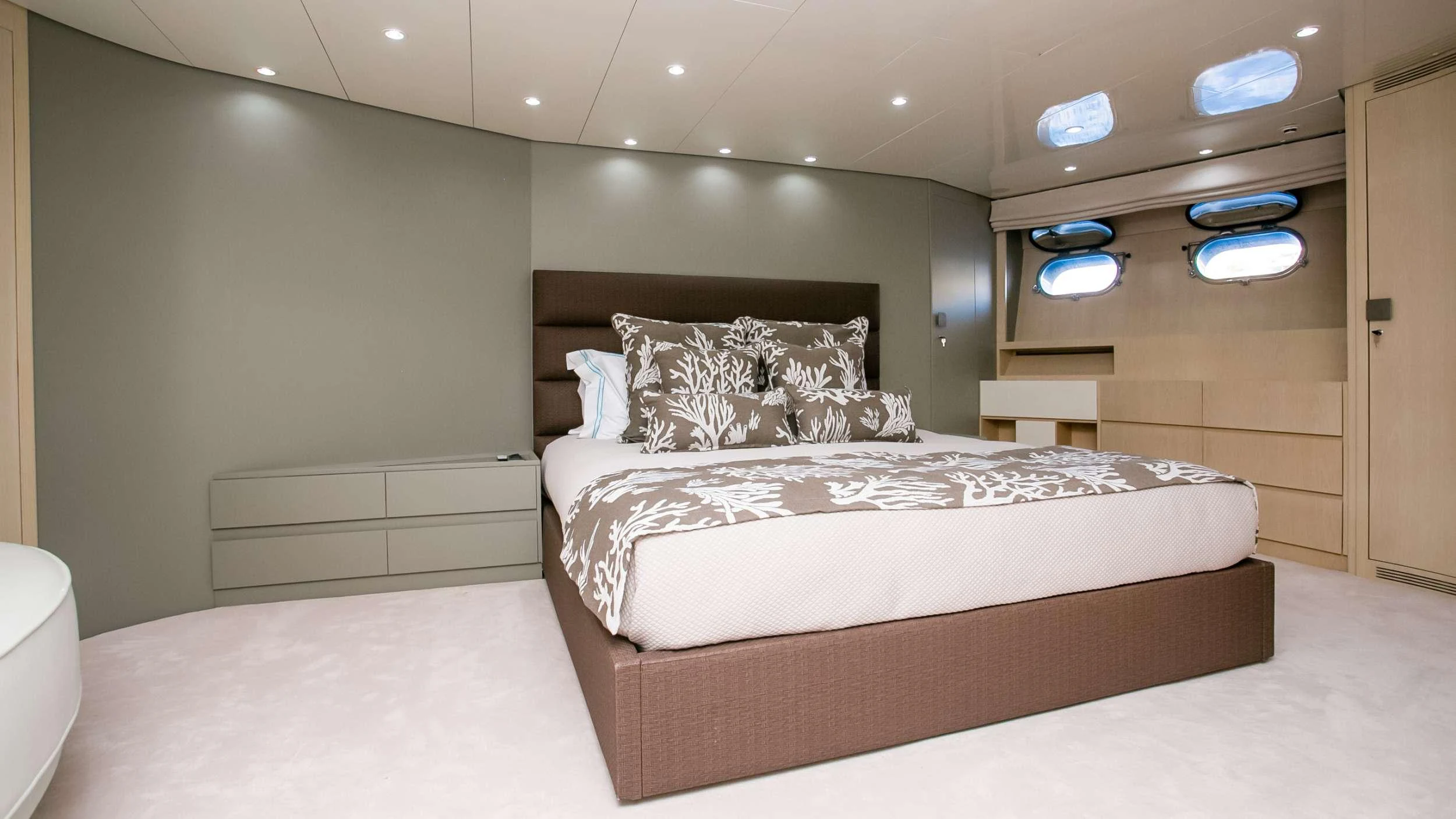 a bedroom with a bed and a dresser aboard MARAYA Yacht for Charter