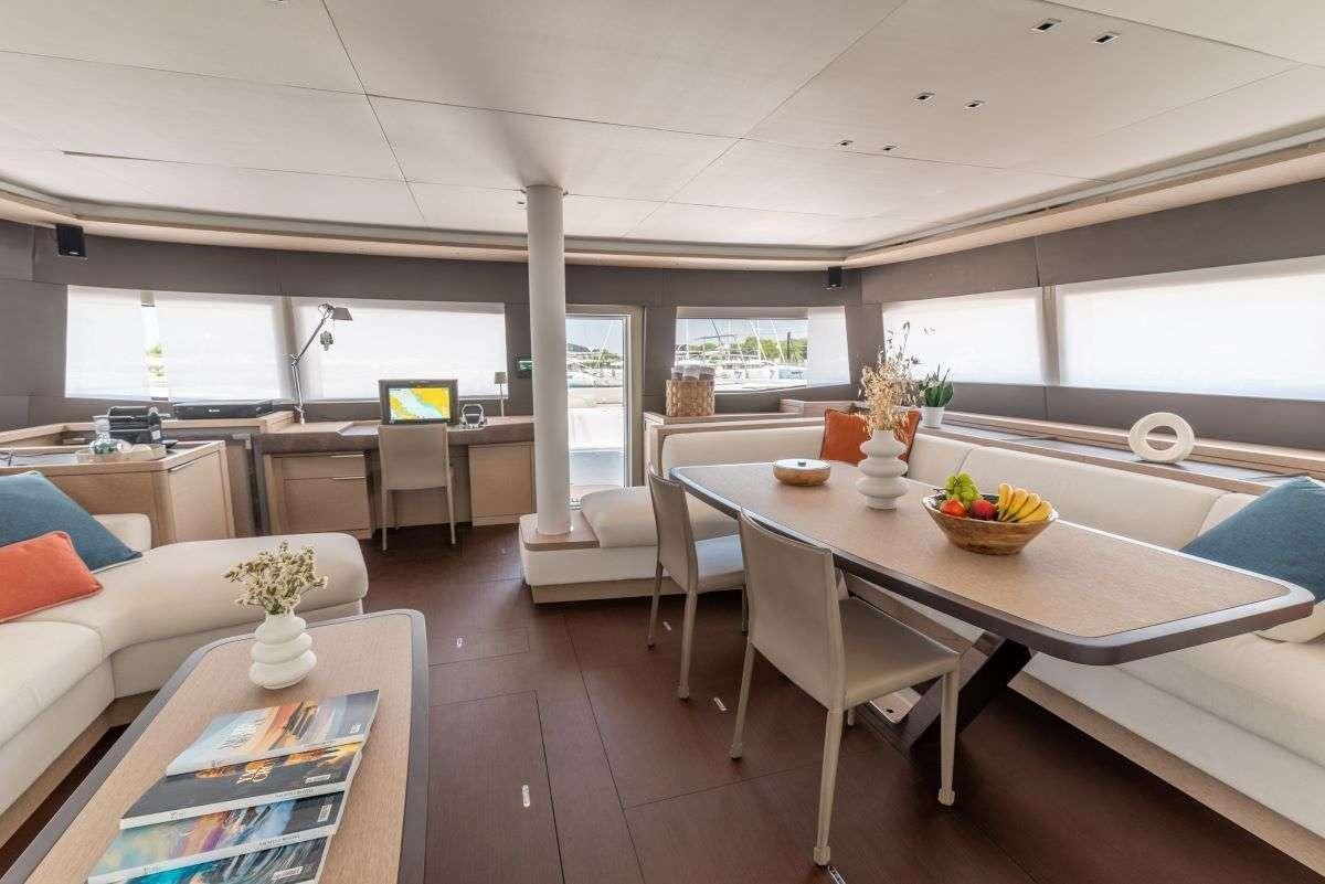 a large living room with a table and chairs aboard SEADUCTIVE ORCA Yacht for Charter