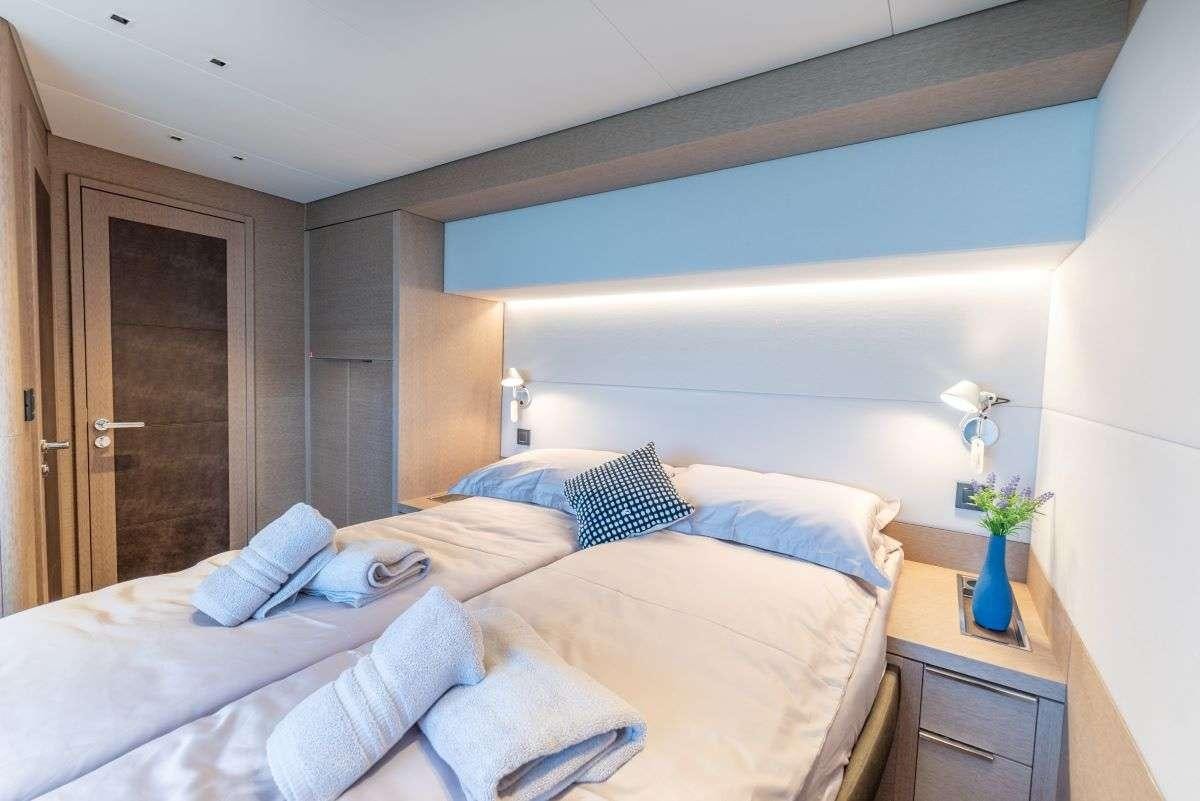 a bed with a blue pillow aboard SEADUCTIVE ORCA Yacht for Charter