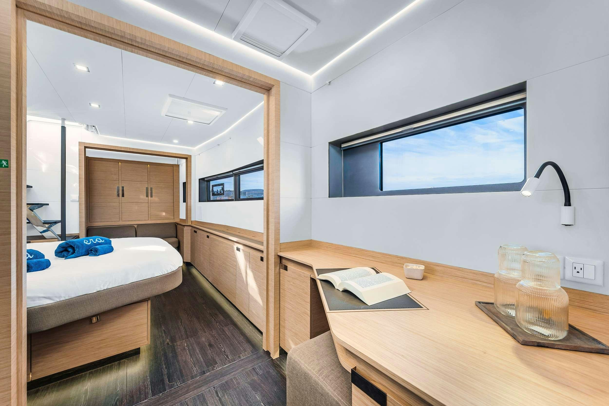 a room with a bed and a television aboard ERA Yacht for Charter