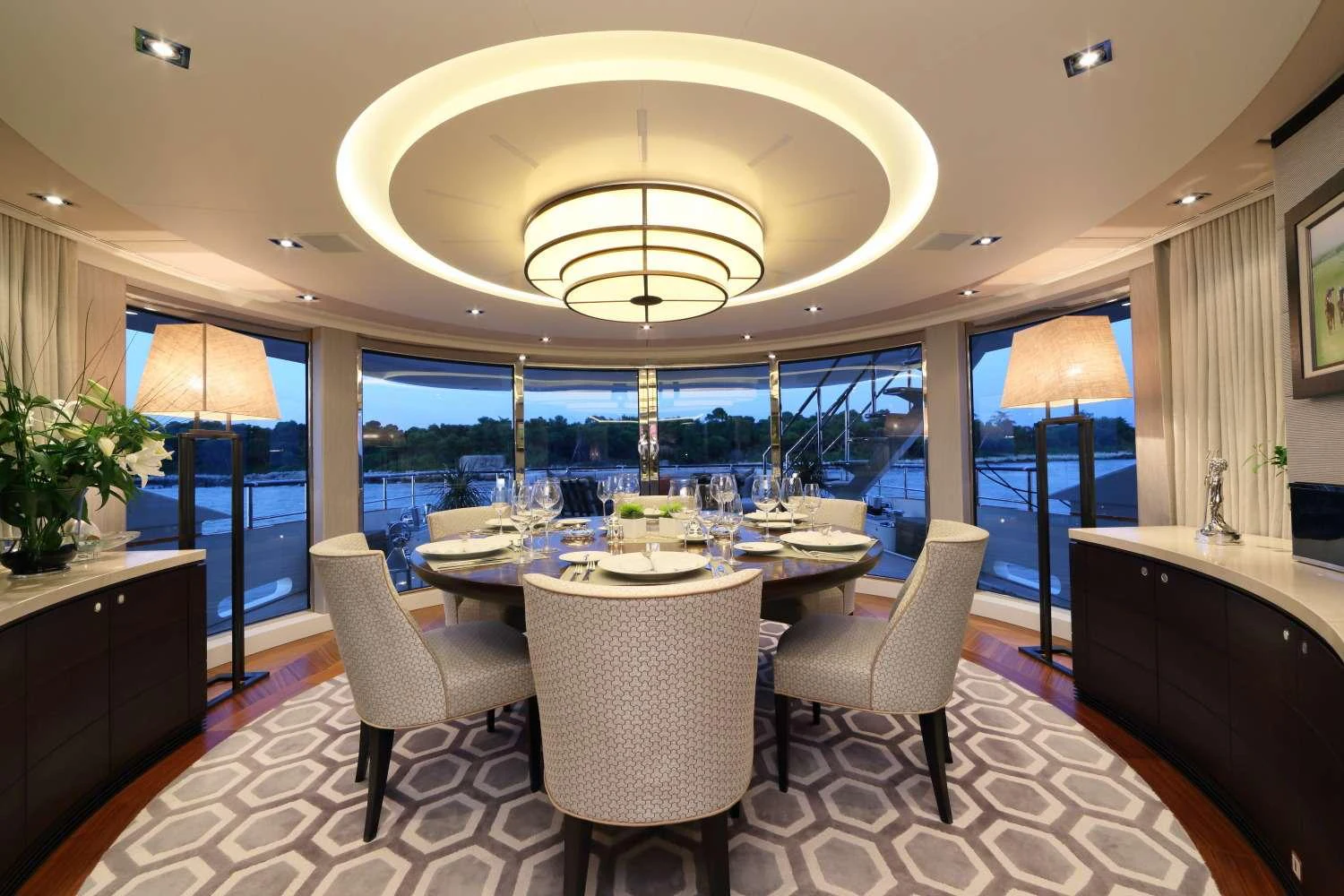 a room with a table chairs and a chandelier aboard AURELIA Yacht for Charter