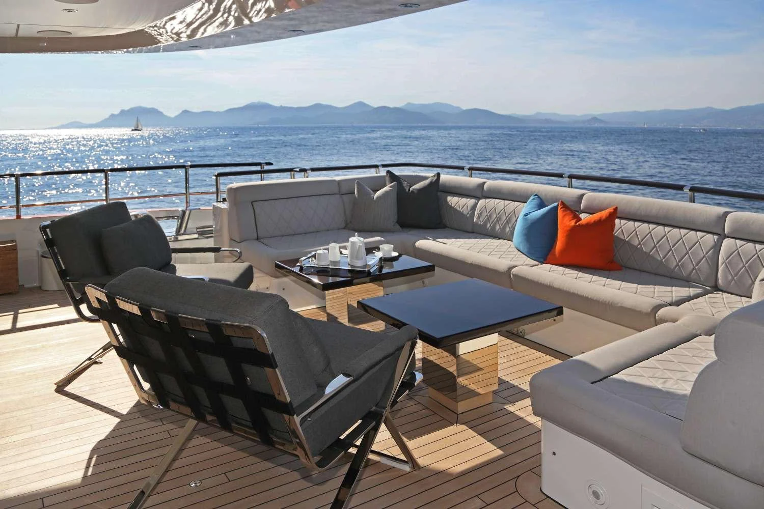 a couch and a table on a deck overlooking a large body of water aboard AURELIA Yacht for Charter