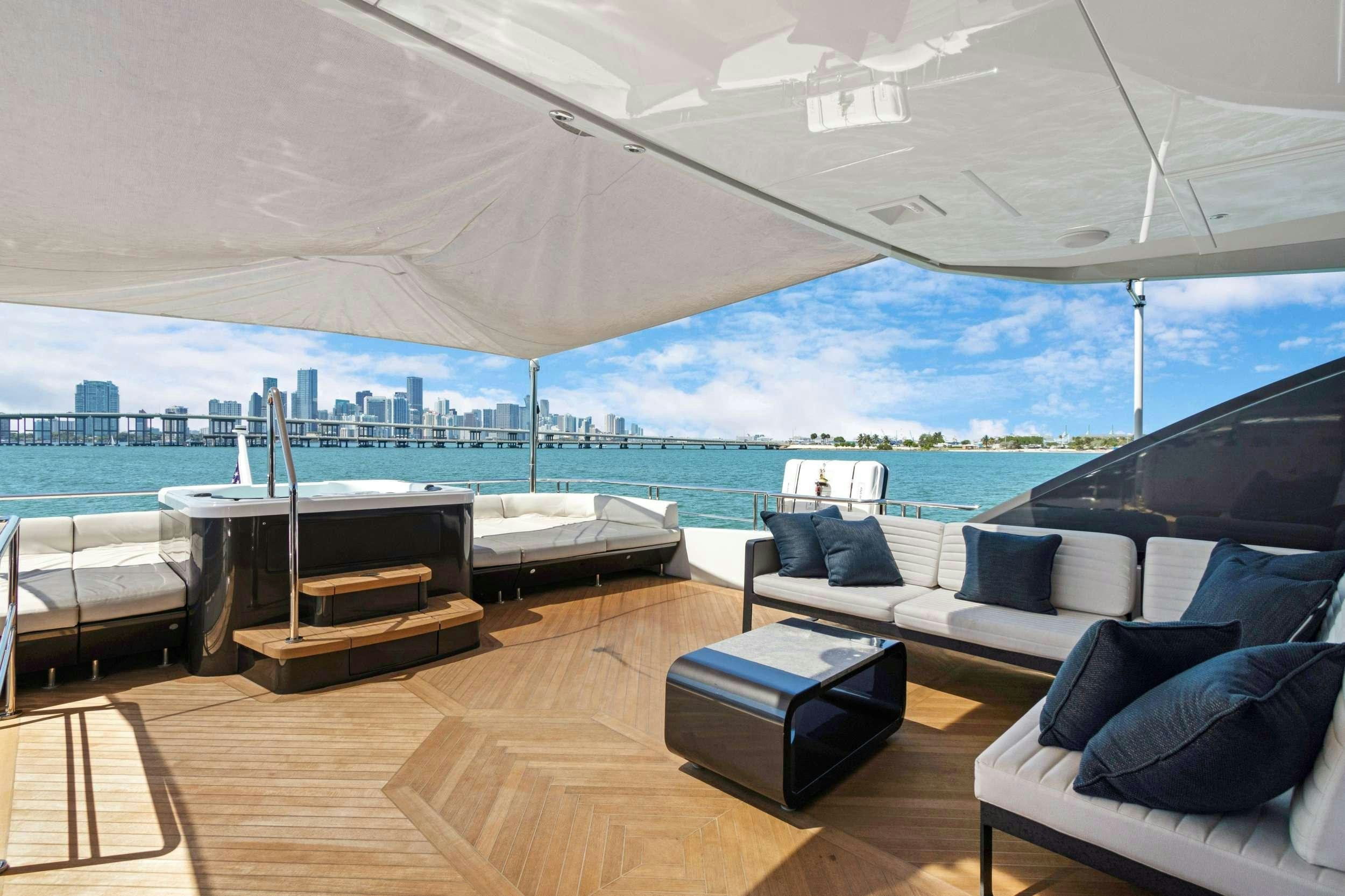 a room with a bed and a table and a large body of water aboard MAKE BIG HAPPEN Yacht for Charter