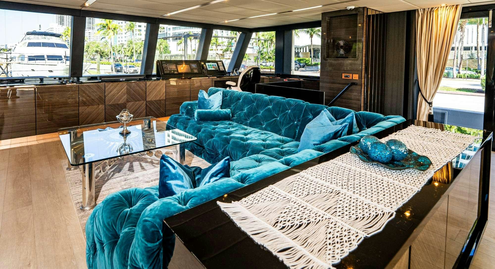 a couch with a table and chairs in a room with a window aboard ROCK STAR 2.0 Yacht for Charter