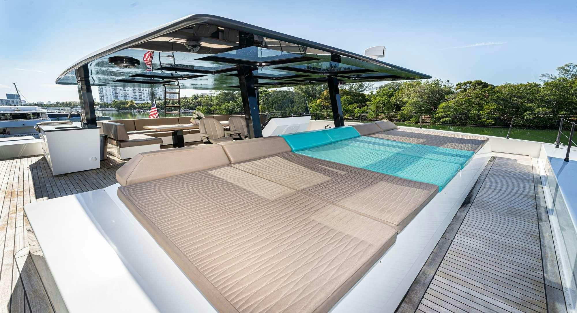 a deck with a pool and a deck with chairs and trees aboard ROCK STAR 2.0 Yacht for Charter