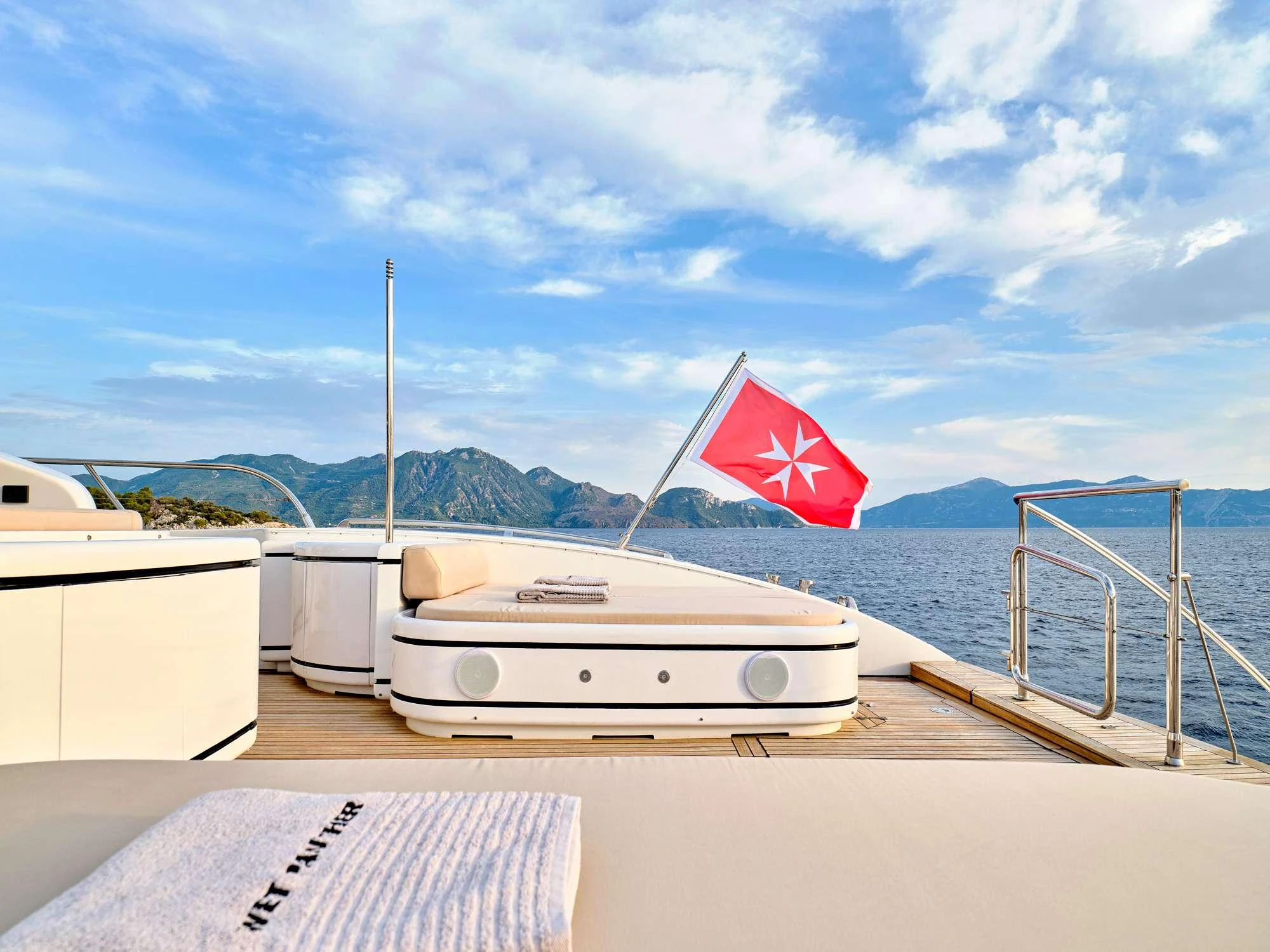 a boat on a body of water with a flag on it aboard WET PANTHER Yacht for Charter