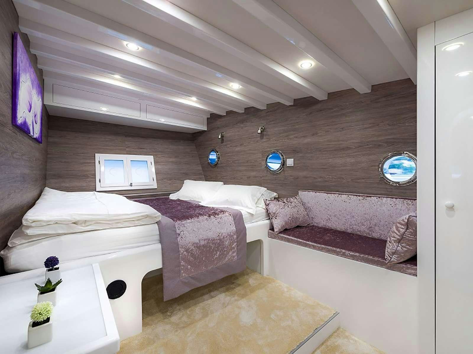 a room with a couple of beds aboard ANĐEO Yacht for Charter