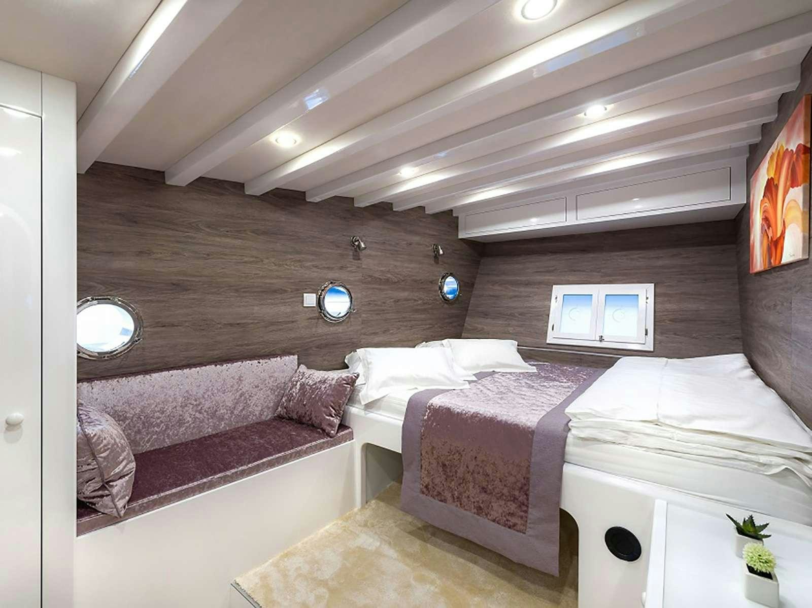 a room with a couple of beds aboard ANĐEO Yacht for Charter