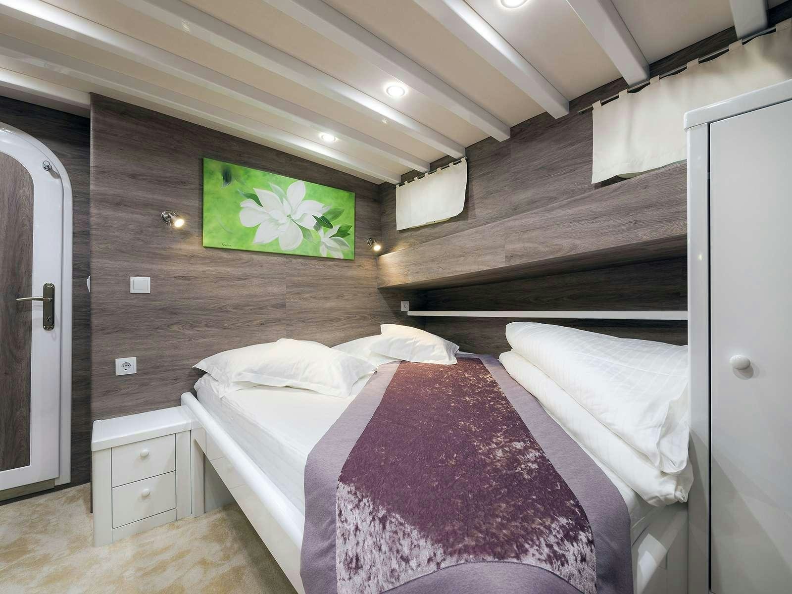 a couple of beds in a cabin aboard ANĐEO Yacht for Charter