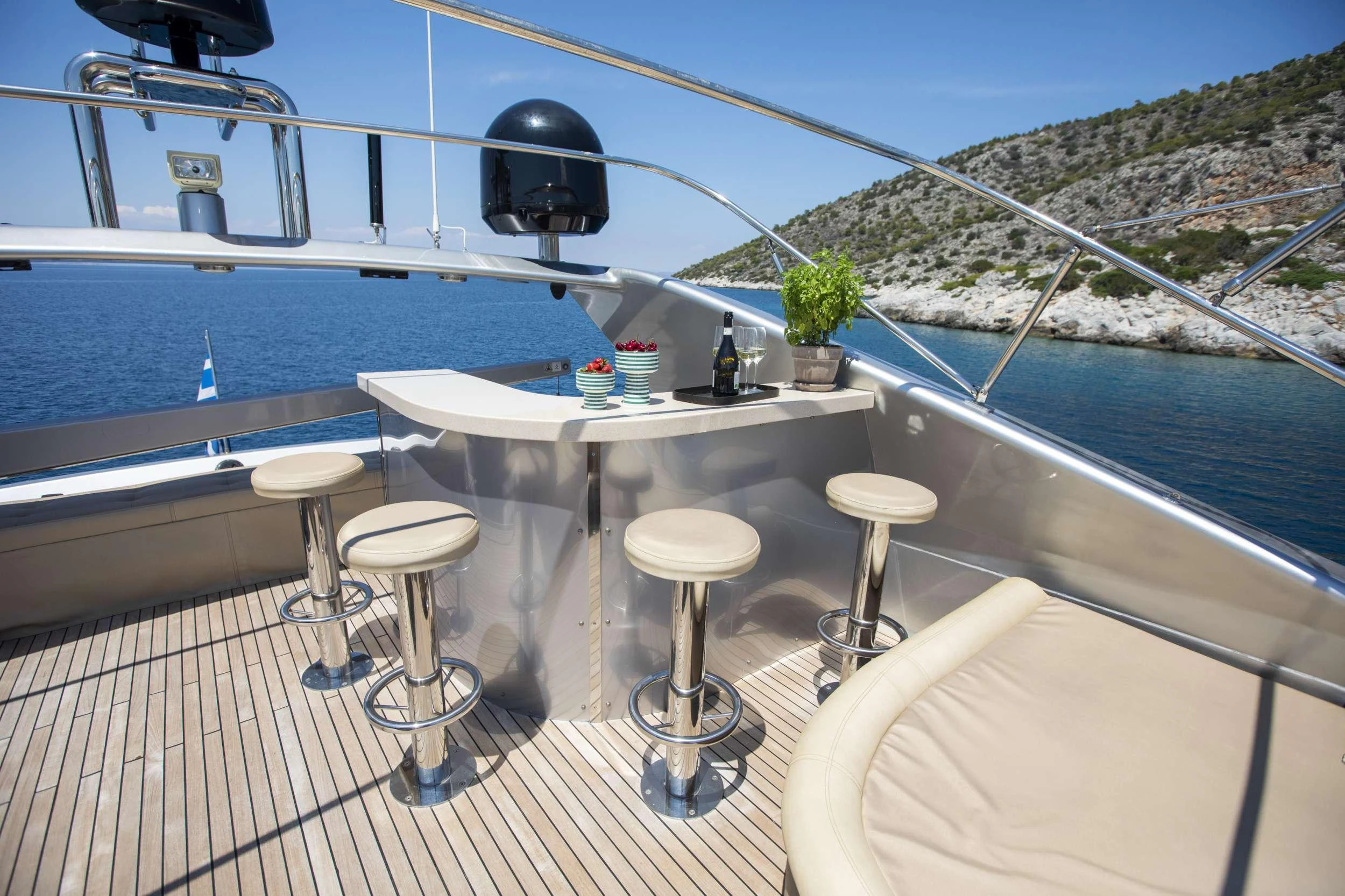 a table with stools on a deck overlooking a body of water aboard ANDROMEDA Yacht for Charter