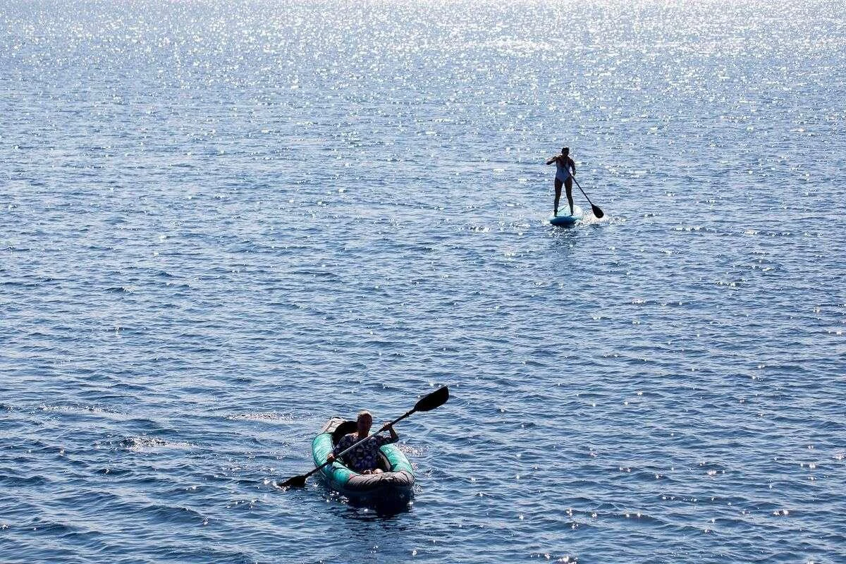 a couple of people rowing on a lake aboard ANDROMEDA Yacht for Charter
