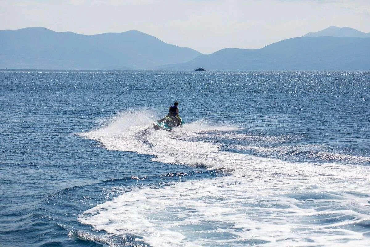 a man riding a jet ski aboard ANDROMEDA Yacht for Charter