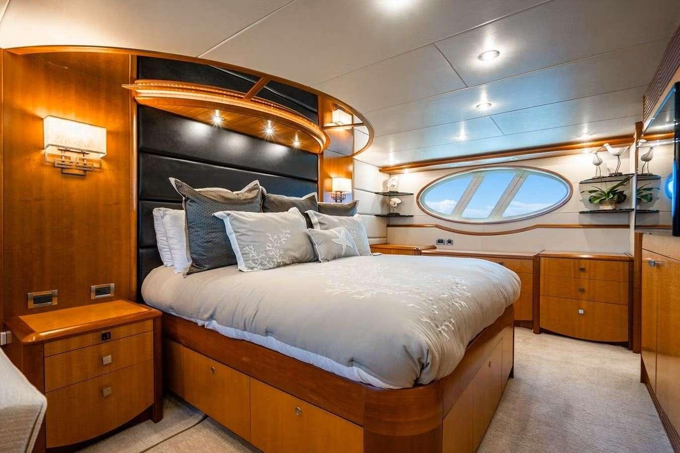a bed with a white bed spread aboard VOYAGER Yacht for Charter