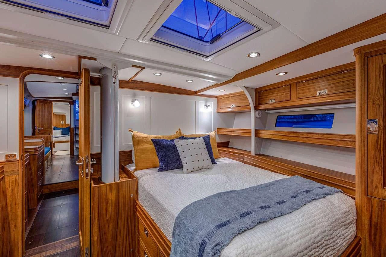a bedroom with a bed and a wood door aboard CIRRUS Yacht for Charter