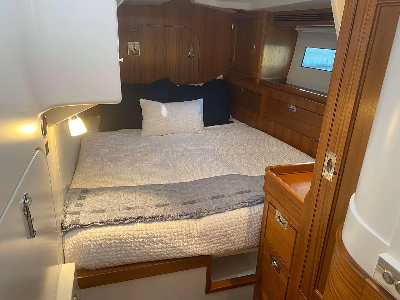 a bed with a blue pillow aboard CIRRUS Yacht for Charter