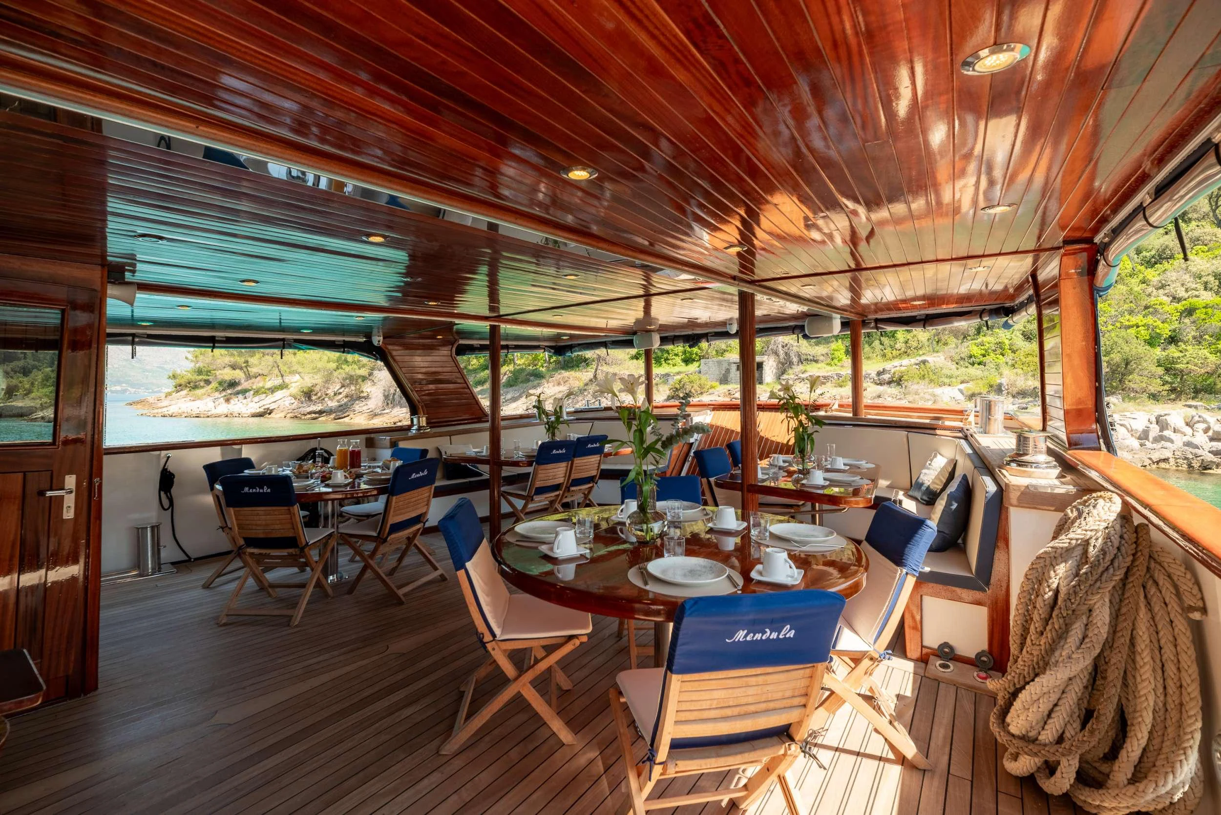 a wood table with chairs and a wood ceiling with a wood ceiling aboard MENDULA Yacht for Charter