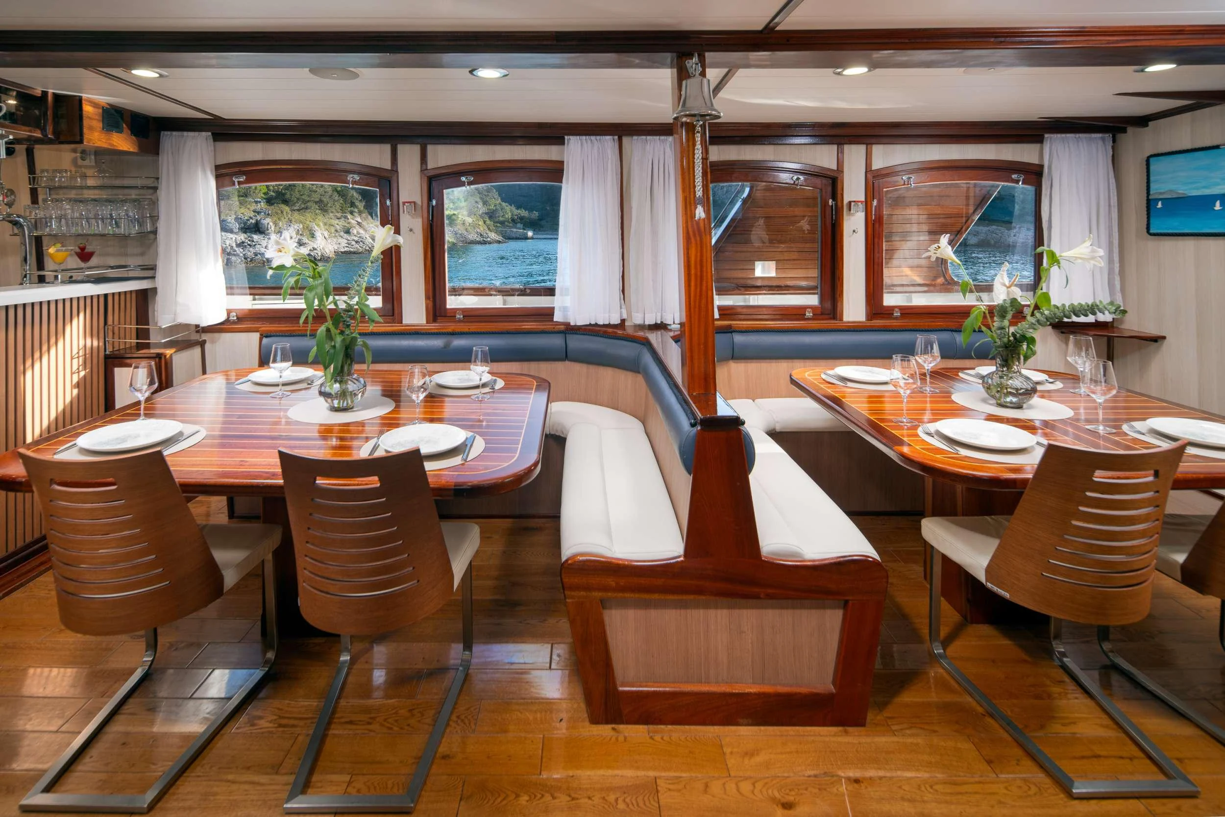 a room with tables and chairs aboard MENDULA Yacht for Charter