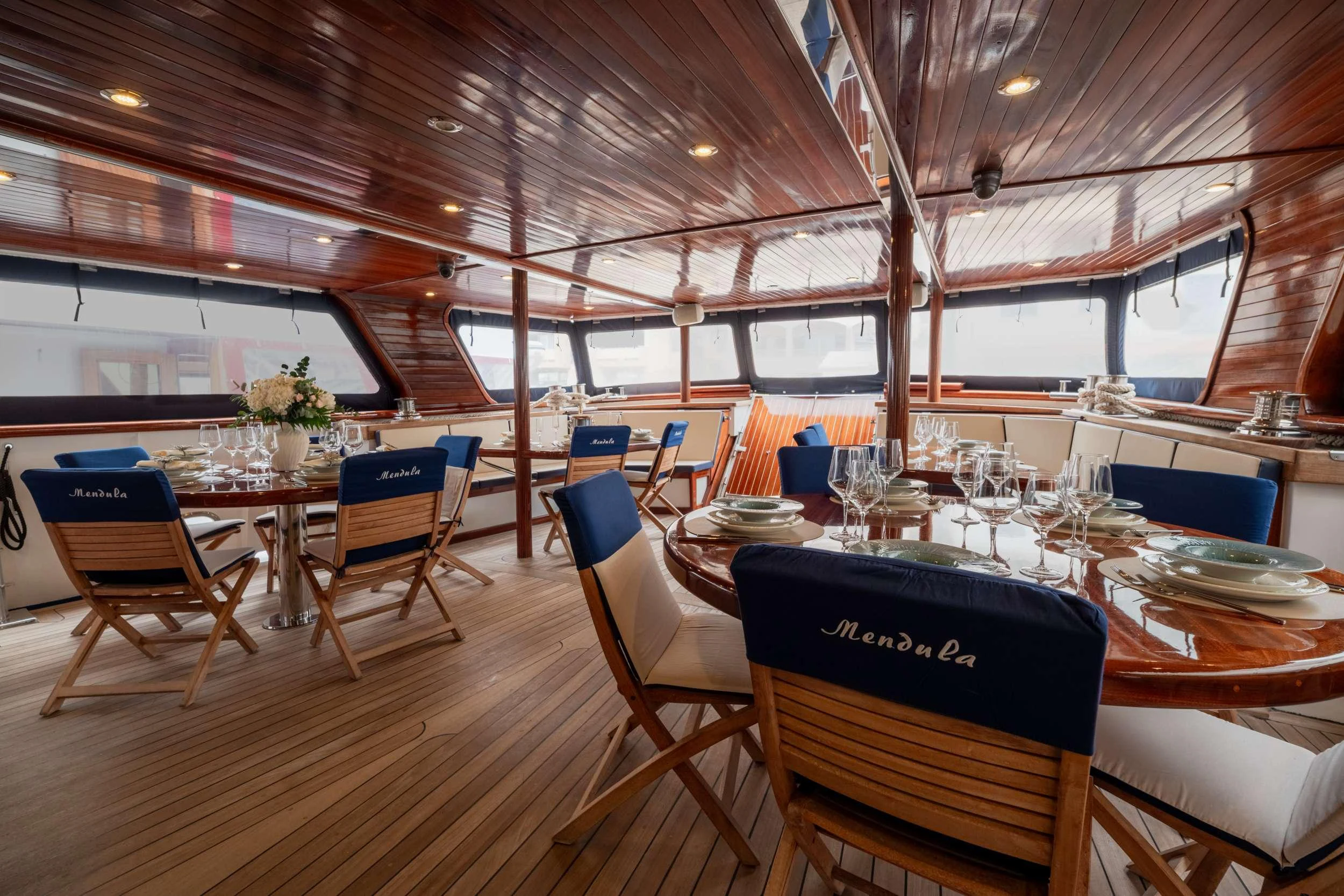 a restaurant with tables and chairs aboard MENDULA Yacht for Charter