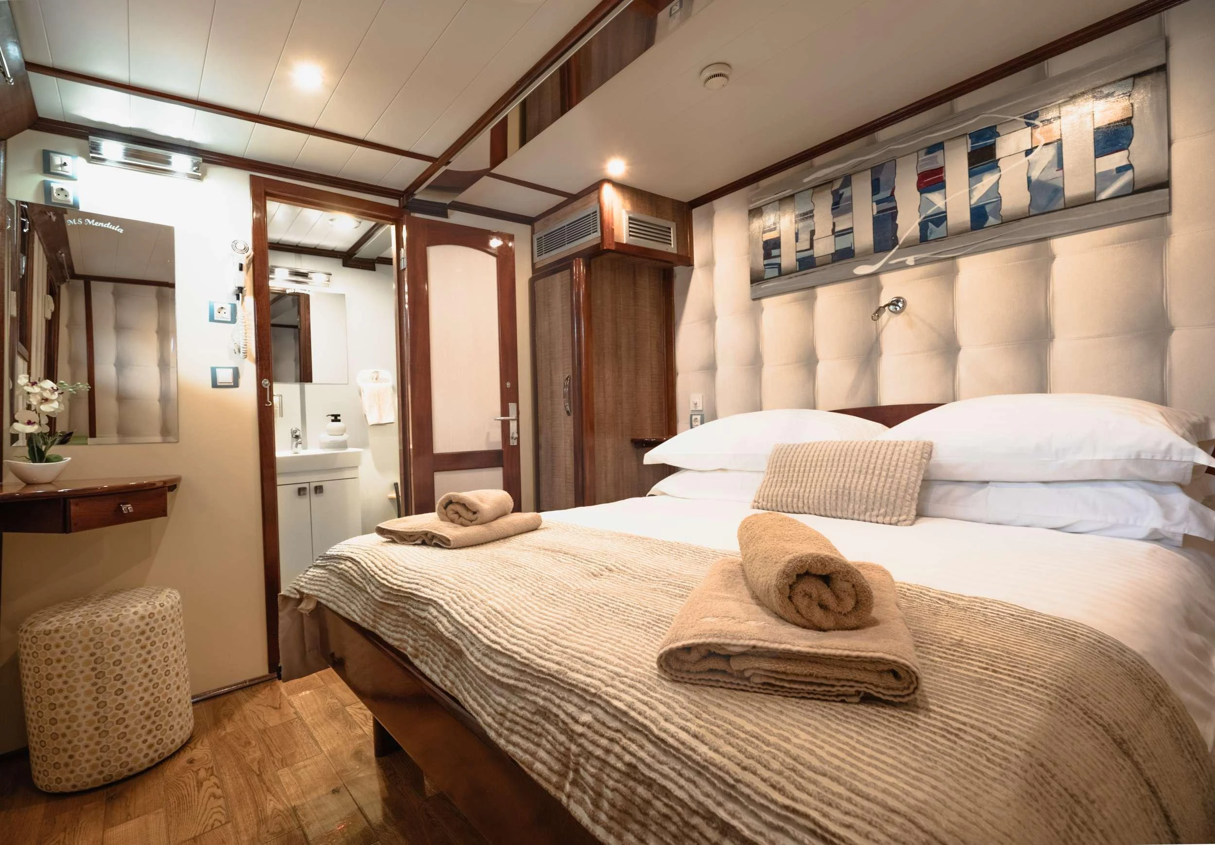 a bed with a hat on it aboard MENDULA Yacht for Charter
