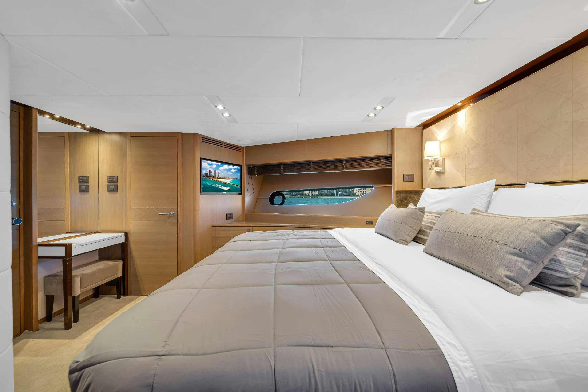 a room with a bed and a television aboard FREEDOM Yacht for Charter