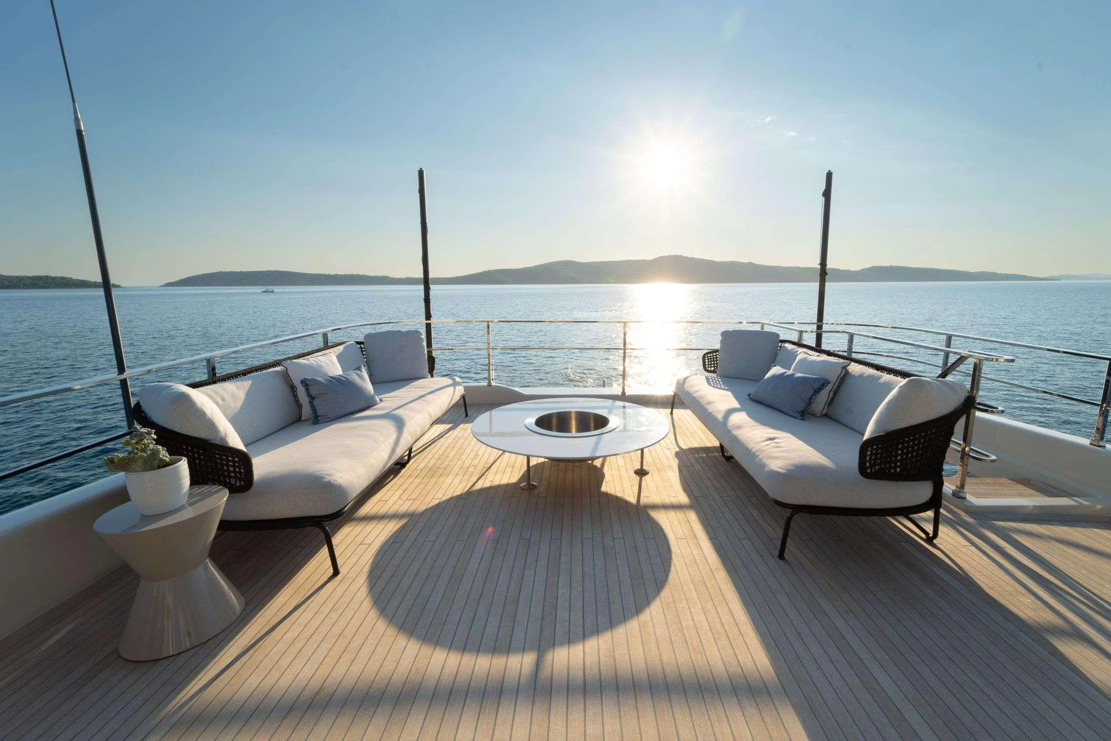 a patio with a table and chairs on it by the water aboard SK Yacht for Charter