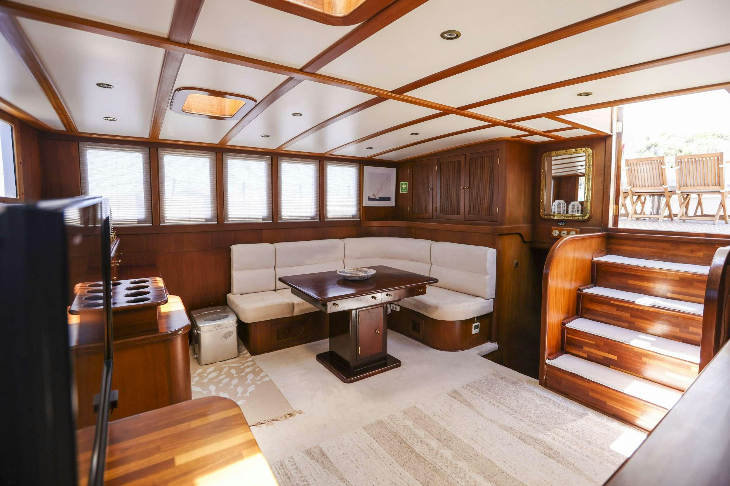 a room with a couch and a table and a piano aboard GAZELLA Yacht for Charter