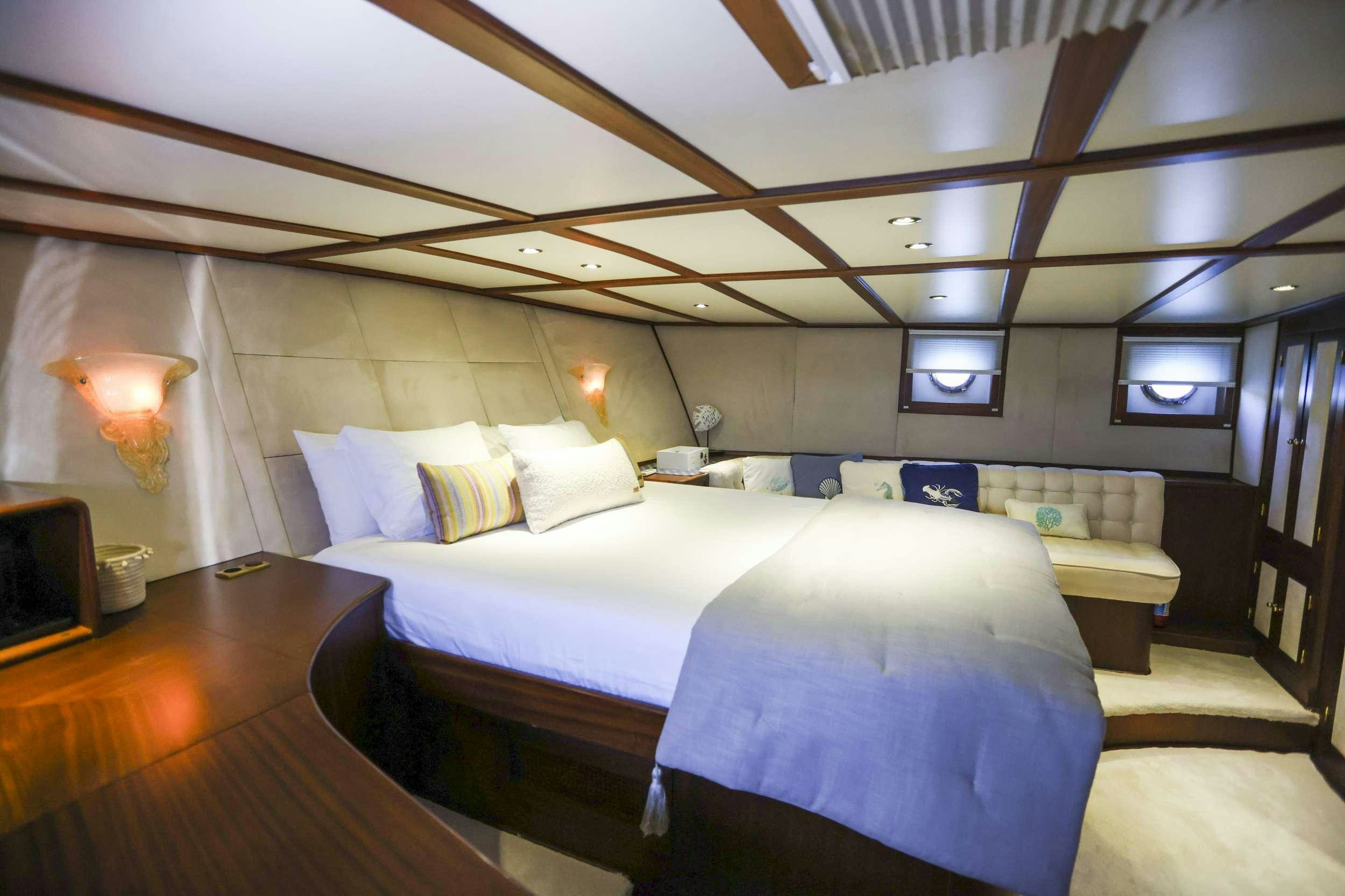 a room with a bed and a television aboard GAZELLA Yacht for Charter