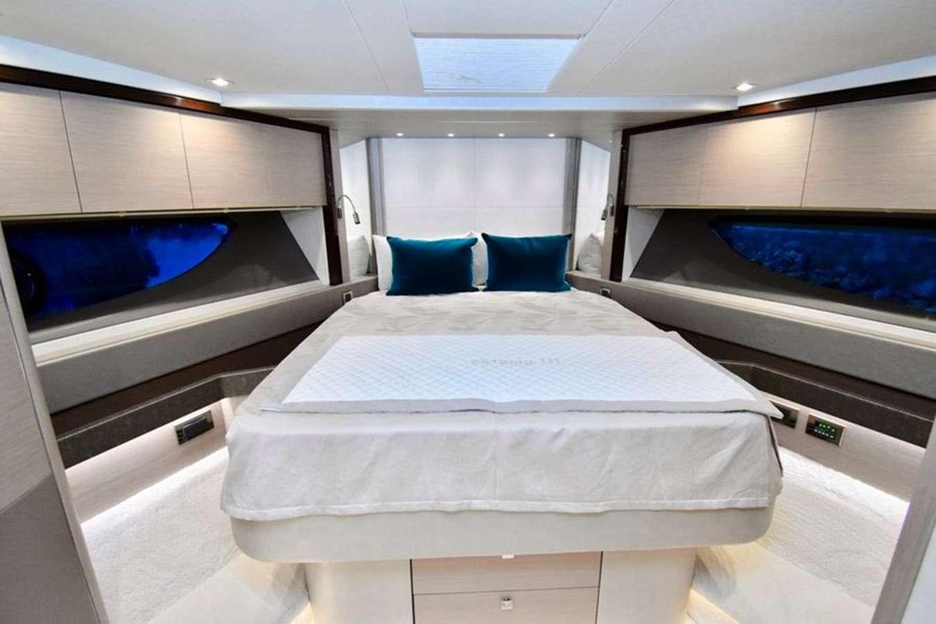 a room with a bed and a couple of blue pillows aboard DO  ANYWAY Yacht for Charter