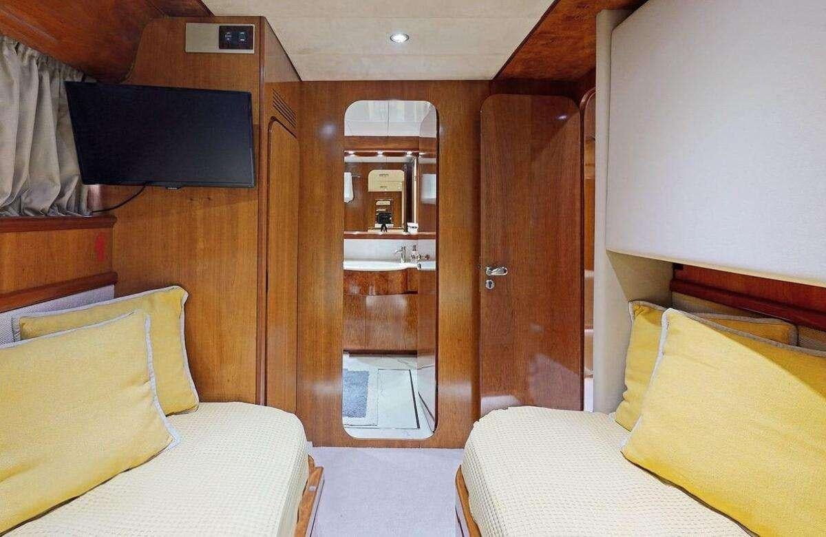 a room with a bed and a mirror aboard STRESS NEGATIVE Yacht for Charter