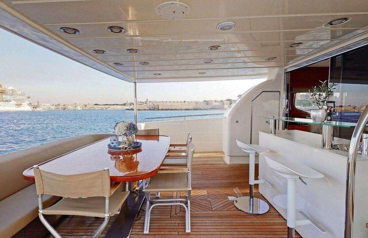 a boat with a table and chairs aboard STRESS NEGATIVE Yacht for Charter