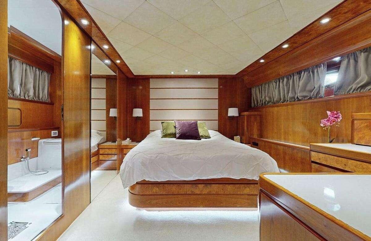 a room with a bed and a mirror aboard STRESS NEGATIVE Yacht for Charter
