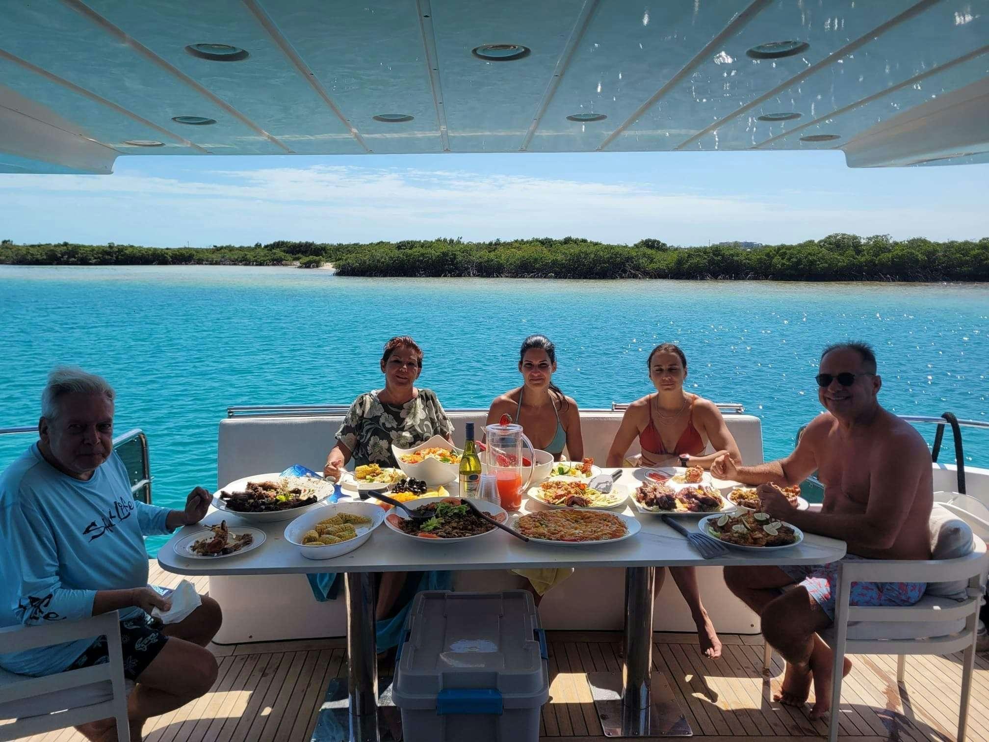 a group of people sitting at a table with food on it aboard SAPHIRE BLUE Yacht for Charter