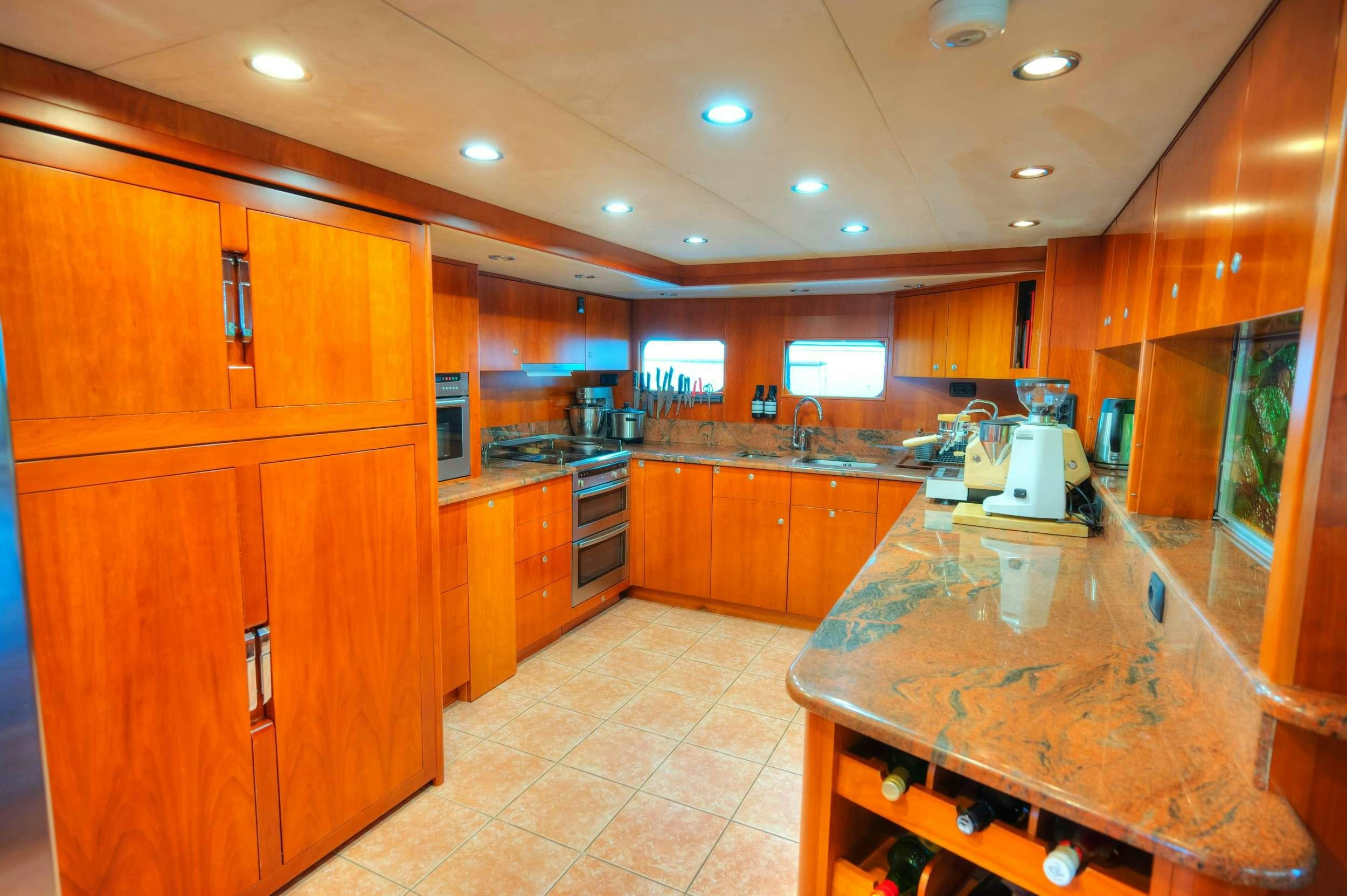 a kitchen with wooden cabinets aboard VOYAGER Yacht for Charter