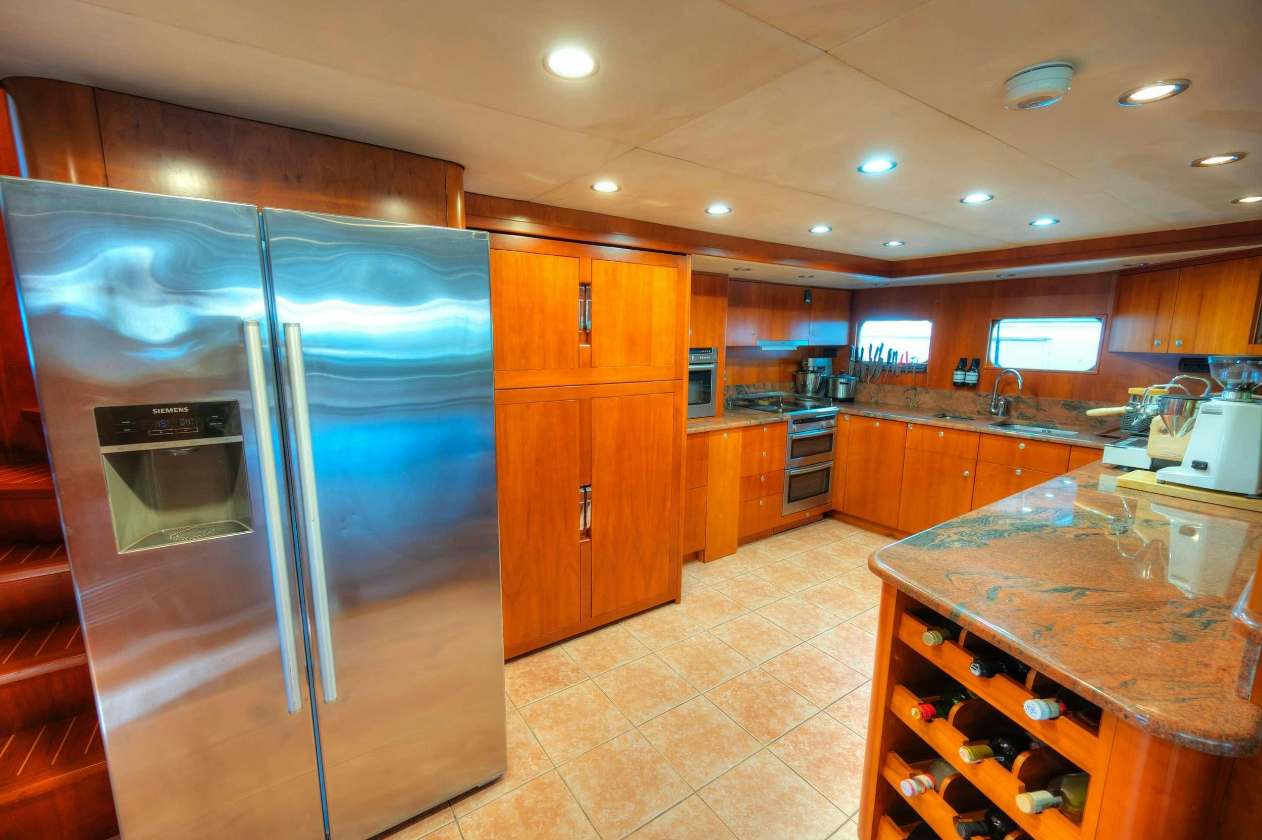 a kitchen with a stainless steel refrigerator aboard VOYAGER Yacht for Charter