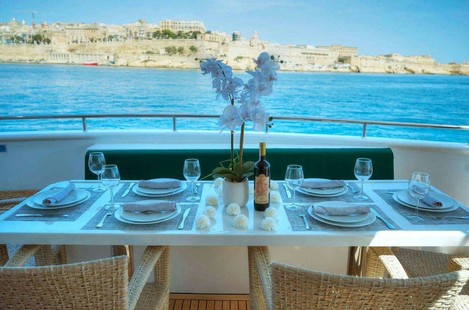 a table set with wine glasses and flowers on it aboard VOYAGER Yacht for Charter