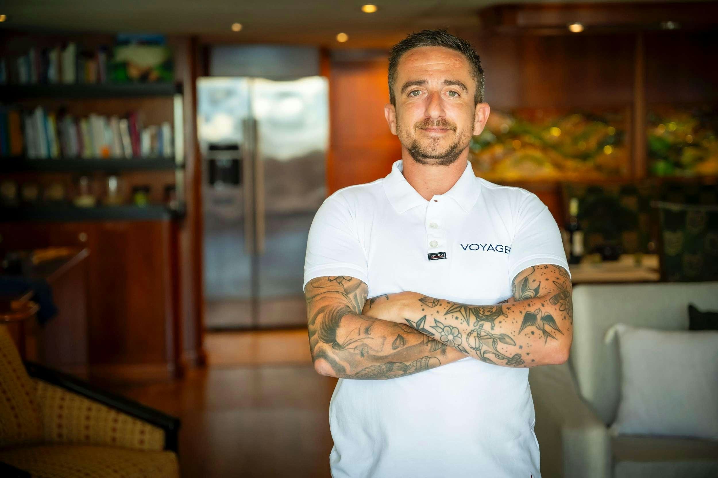 a man with tattoos aboard VOYAGER Yacht for Charter