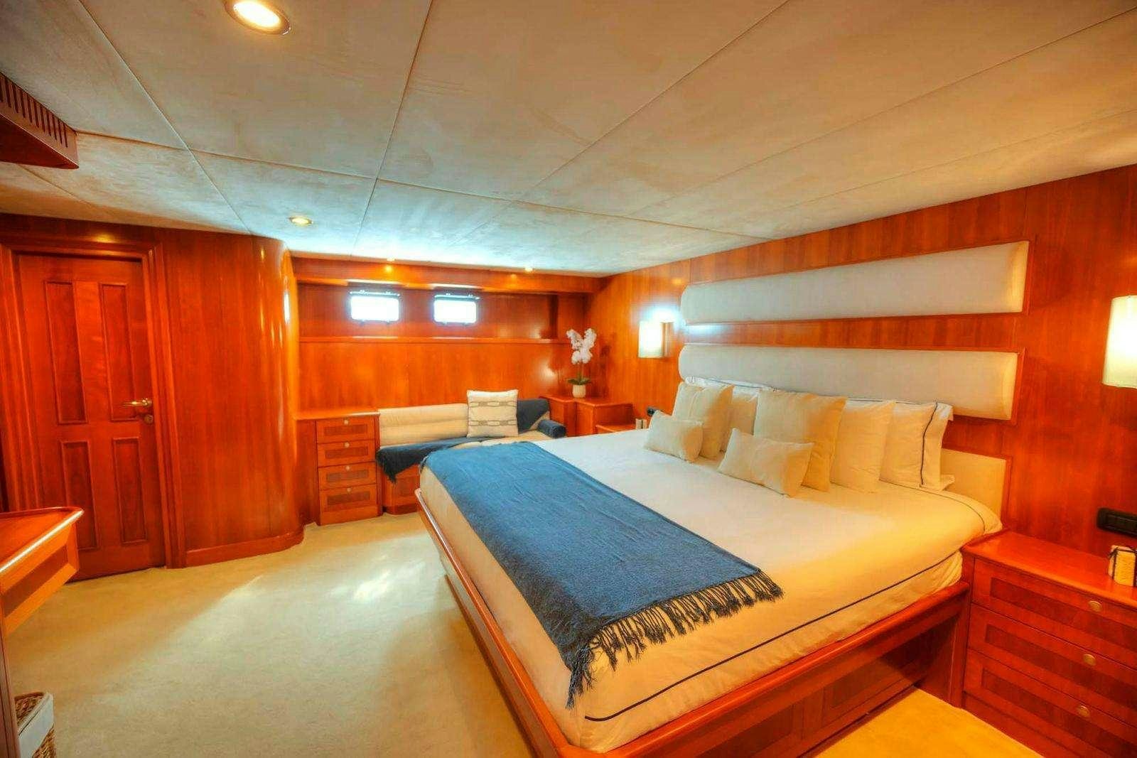 a room with a bed and a desk aboard VOYAGER Yacht for Charter
