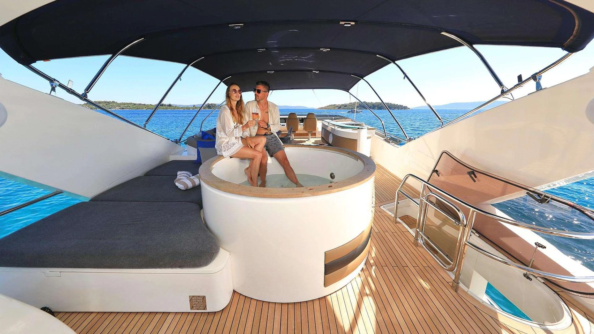 a man and woman sitting on a boat aboard INSIEME Yacht for Charter